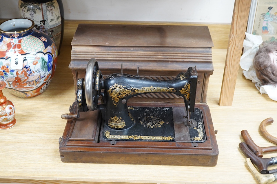 An early 20th century cased Singer sewing machine, 46cm wide at base. Condition - poor